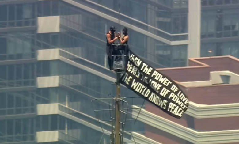 Duas pessoas escalam o topo do Empire State Building carregando uma faixa em 1º de julho de 2026 • WABC